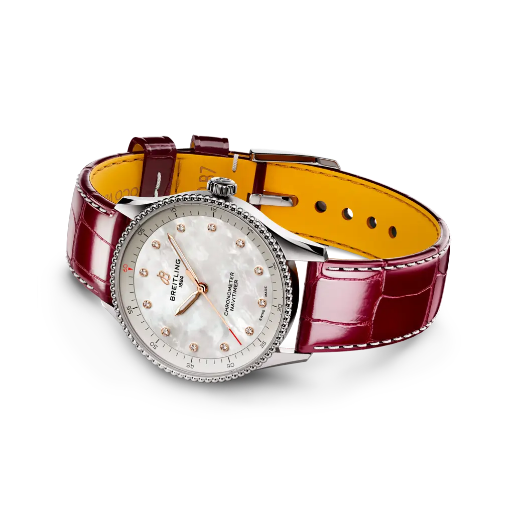 Dettaglio delle lancette luminose e lunetta a perline dell’orologio Navitimer 32, con puntale rosso dei secondi.