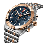 Load image into Gallery viewer, Dettaglio del bracciale Rouleaux bicolore e della corona a vite dell’orologio Breitling Chronomat B01 42.
