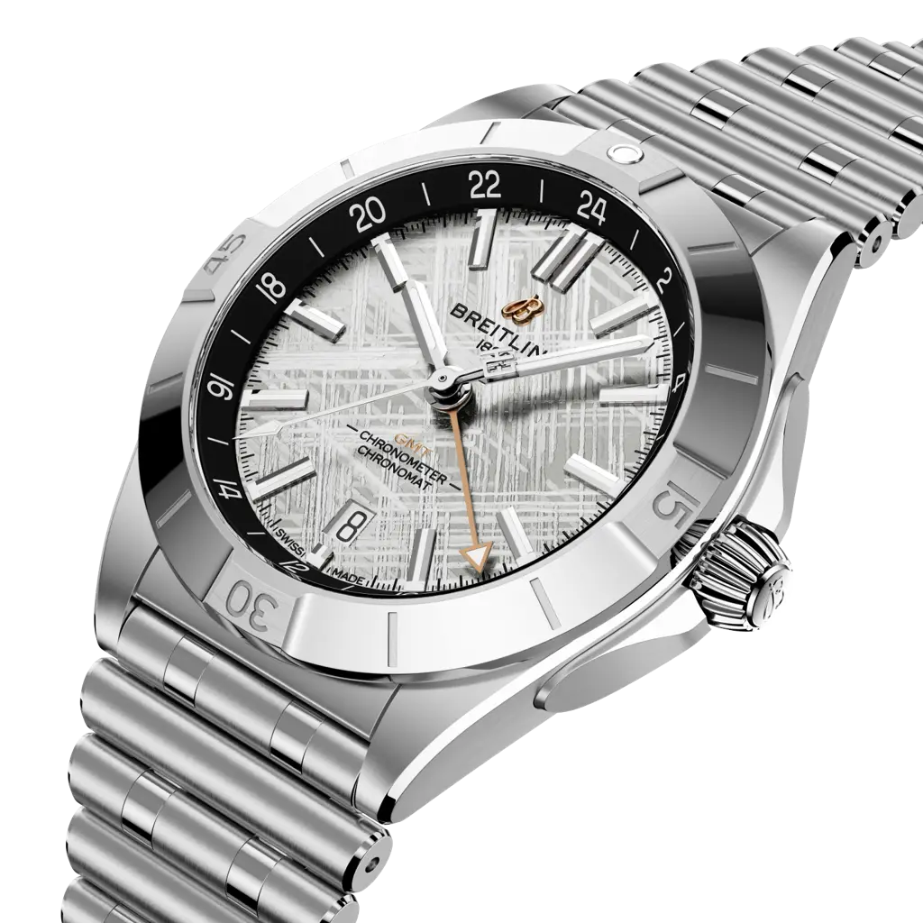 Dettaglio del quadrante con motivo Widmanstätten e lancetta GMT in oro rosso dell’orologio Breitling Chronomat GMT.